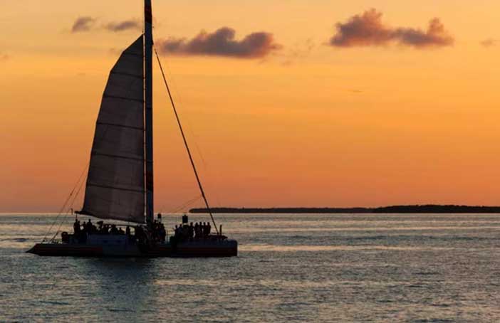 Dar un paseo en catamarán al atardecer es un romántico plan en pareja en el Mediterráneo